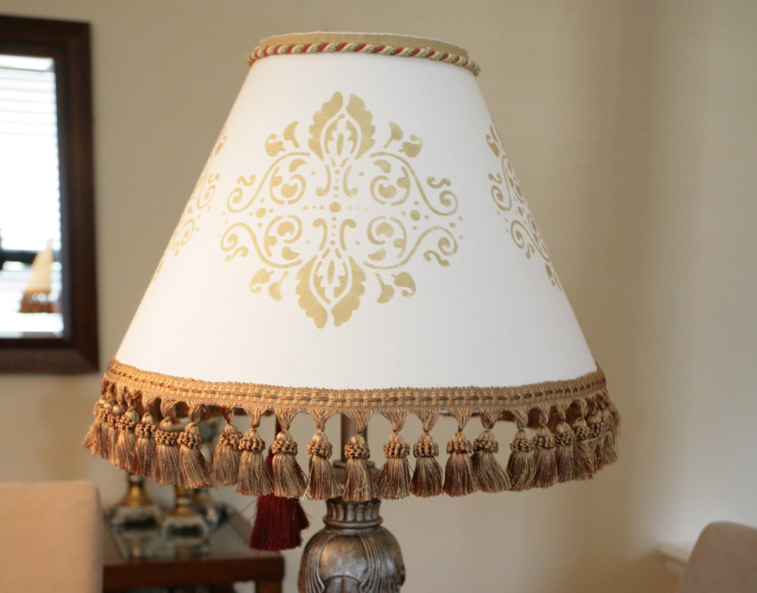 A white lamp shade with a stencil on it.