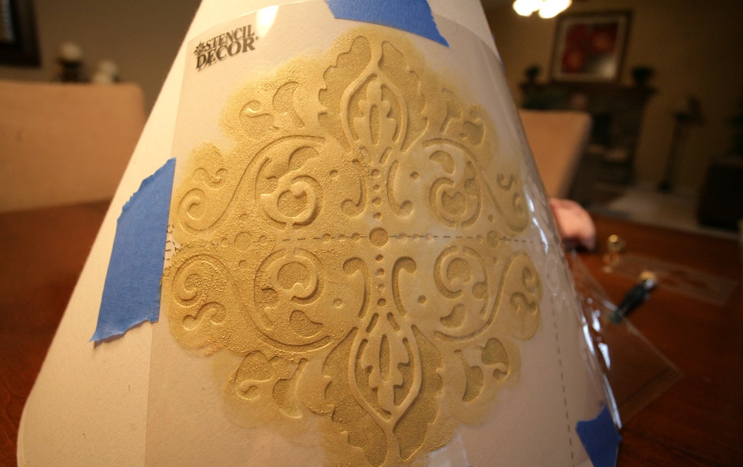 Taping the stencil to the light shade.