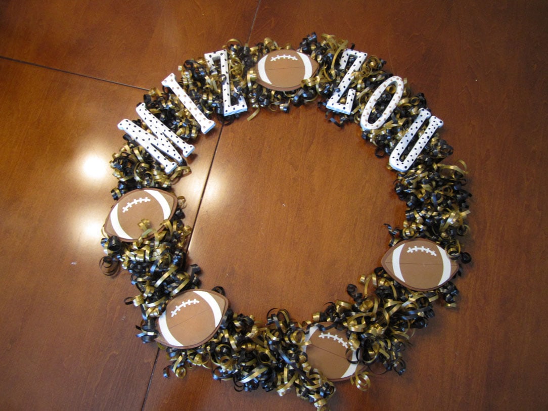 Using the hot glue gun to put the letters and footballs on the wreath.