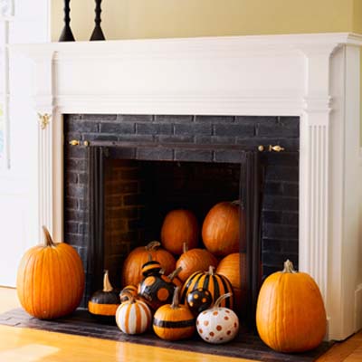 Fireplace with all sizes and shapes of pumpkins in it.