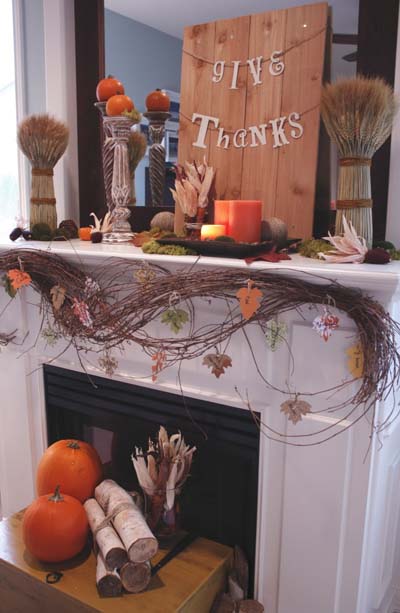 Fireplace mantel decorated with branches and pumpkins.