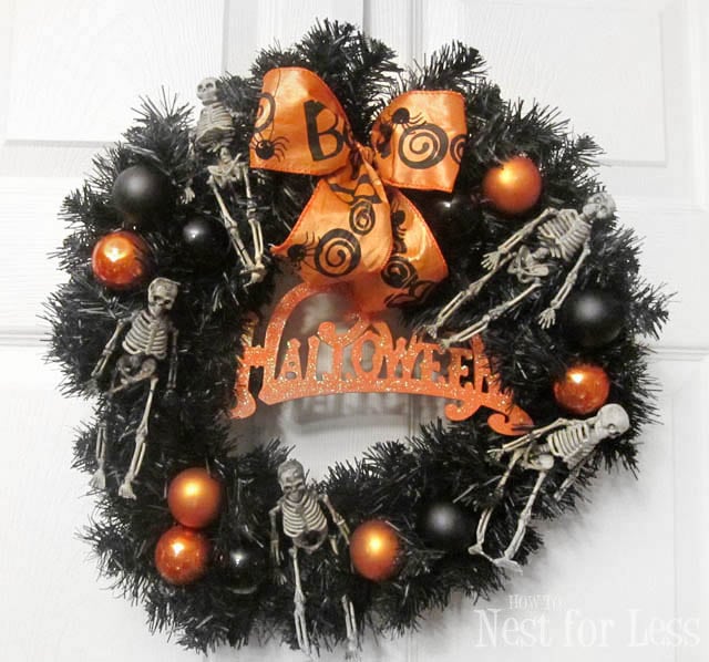 Halloween wreath with orange bow and skeletons.