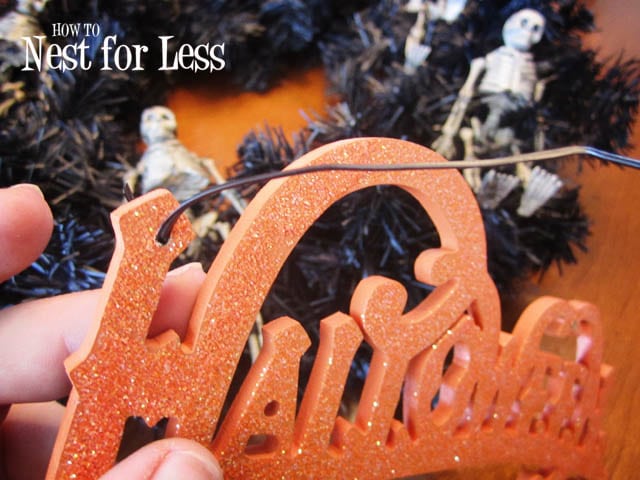 Tying the glitter Halloween sign to the wreath.