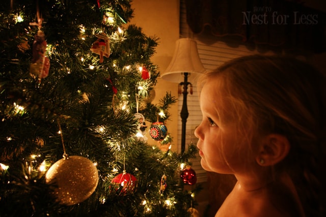 Little girl looking at the decorated Christmas tree.