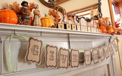 A fireplace mantel with little pumpkins on it.