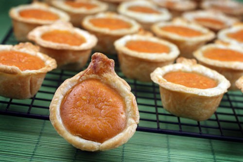 Mini pumpkin pies on a cooling rack.