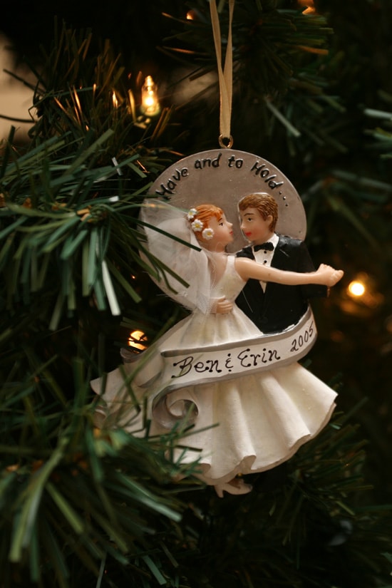 A bride and groom ornament hanging on the tree.