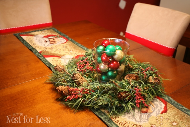 All the Christmas ornaments in a clear glass vase in the middle of the table.