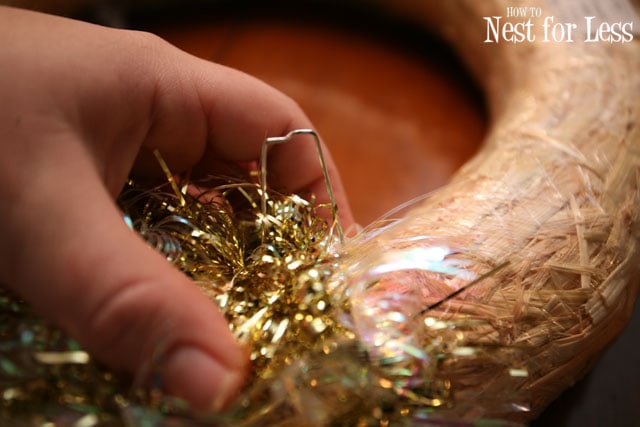 Putting the tinsel on the wreath form with pins.