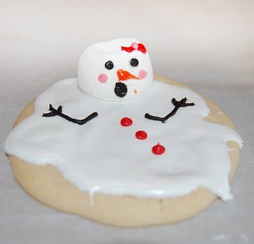 Sugar cookies with a melted looking snowman decorated on top.