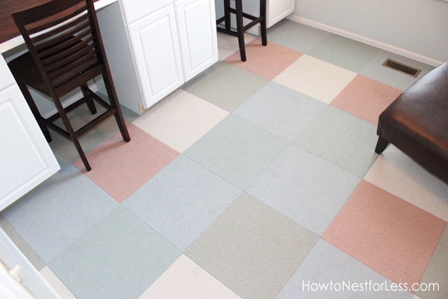 The blue, pink, grey and white carpet tiles in craft room.