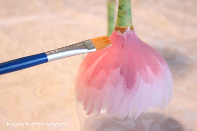 A paint brush adding darker pink to the light pink.