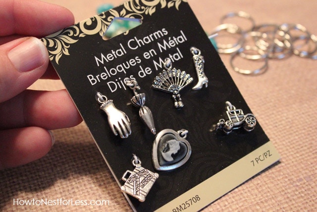 Metal charms in the package being held up.