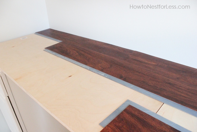 Putting the wooden floor pieces on top of the desk plywood.