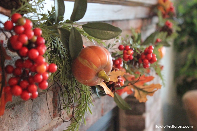 Fall garland with berries and pumpkins on the front of the fireplace.