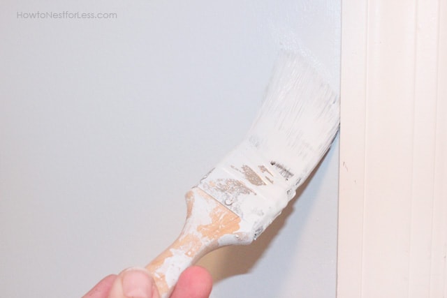 A paint brush with the light blue color on the wall.