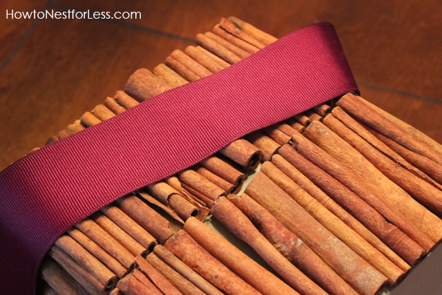 Tying a purple ribbon around the cinnamon tissue box.