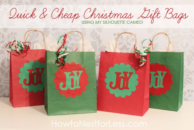 Four Christmas gift bags in red and green in a row on the counter.