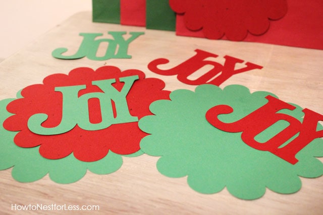 The word Joy cut out on the table in green and red.