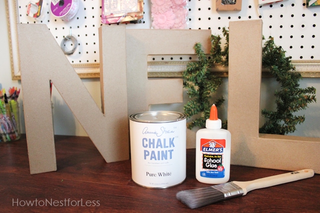 Chalk paint, glue, and brush in front of the N on the sign.