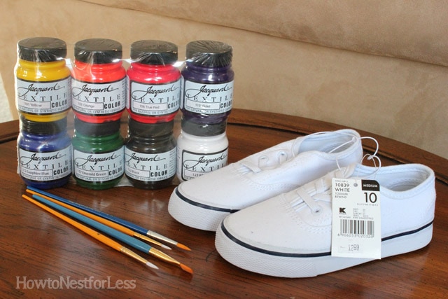 New tennis shoes, paint brushes and paint on the table.