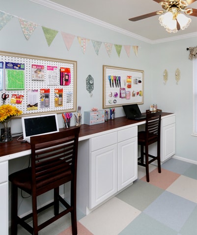 The craft room with desk, cork boards over the desk and two desk chairs.