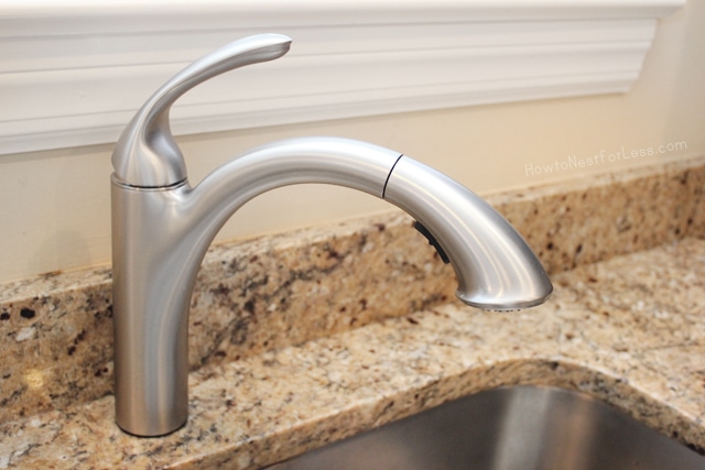 A brushed nickel kitchen faucet is pointed over a stainless steel sink