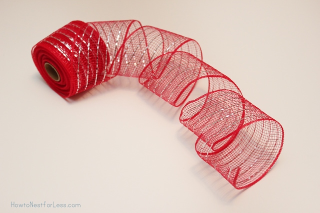 Sparkly red mesh ribbon being unrolled on the counter.