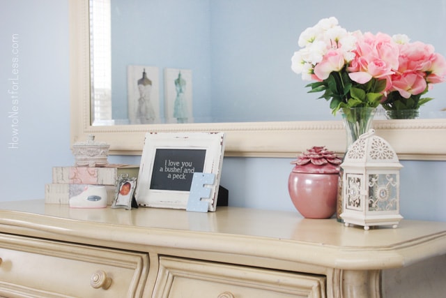 A cream dresser with flowers on it.