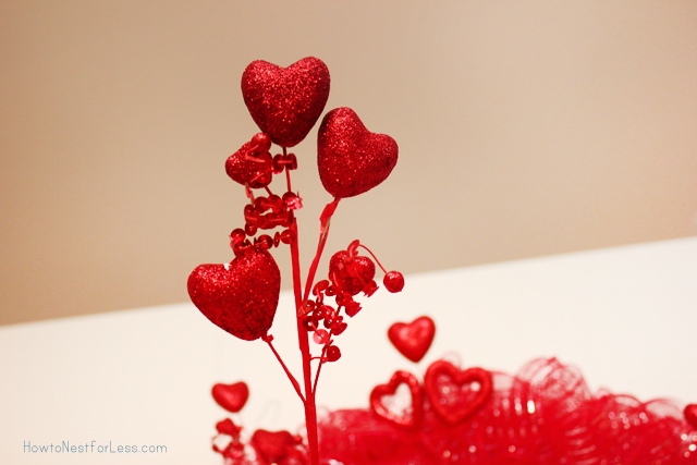 Adding sparkly red hearts to the wreath.