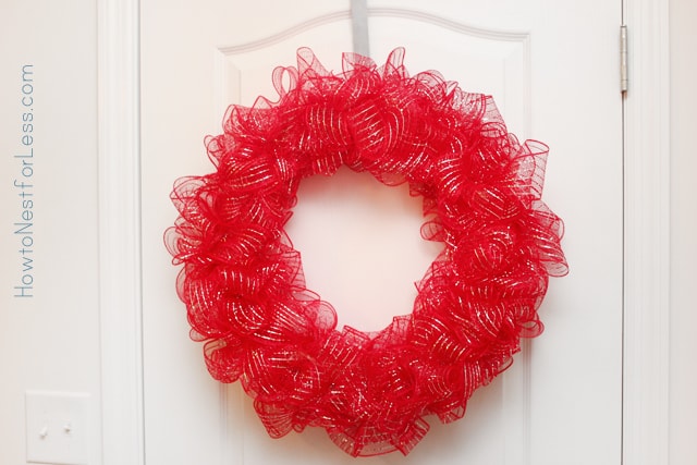 The mesh wreath hanging on a white door.