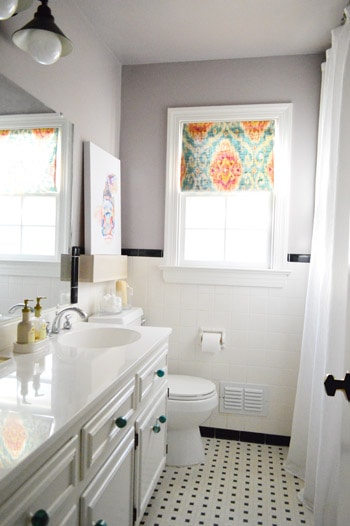 A orange and blue window shade in the bathroom.