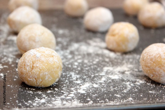 Rolling the dough into balls on a cookie sheet.