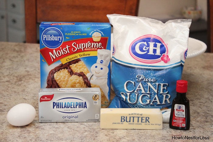 The cane sugar, cream cheese, cake mix and egg, butter and vanilla on the counter.