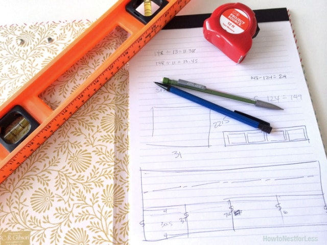 A level and a notebook with drawings of moldings and measurements