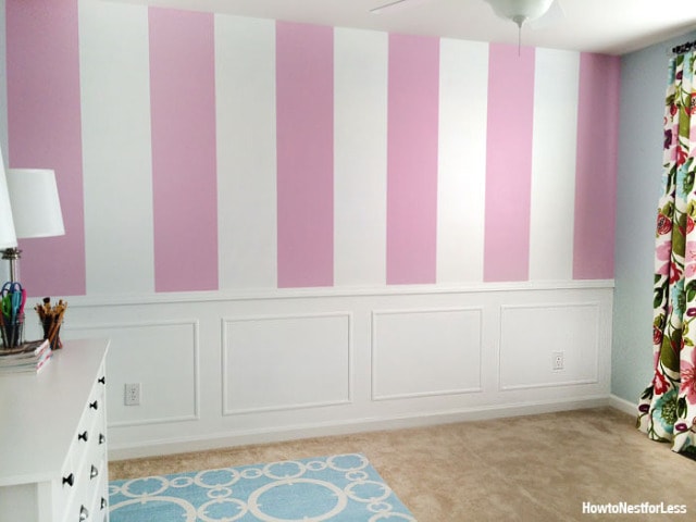 Room with white chair railing and picture frame molding on the lower portion of a wall.