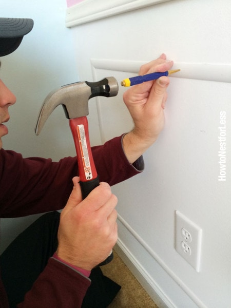 Man using nail set to tap nails into chair rail molding