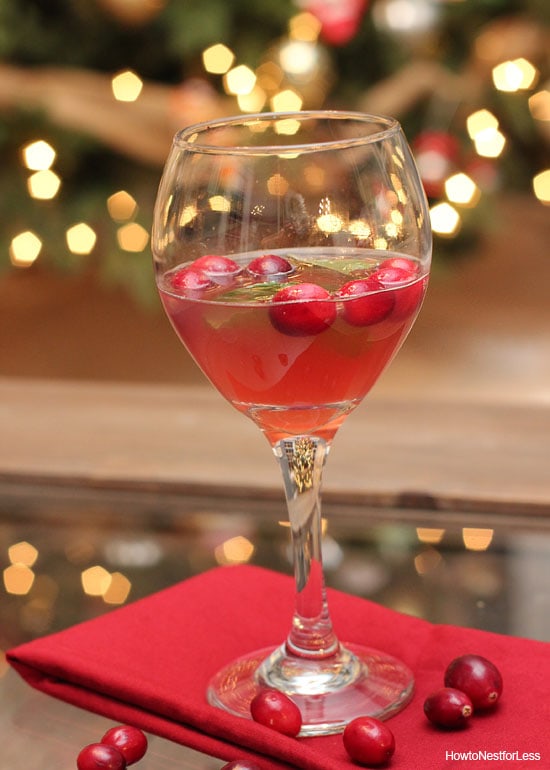 A wine glass filled with cranberries and juice on a red napkin.