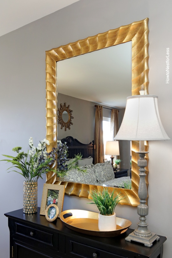 Gold gilded mirror above the dresser.