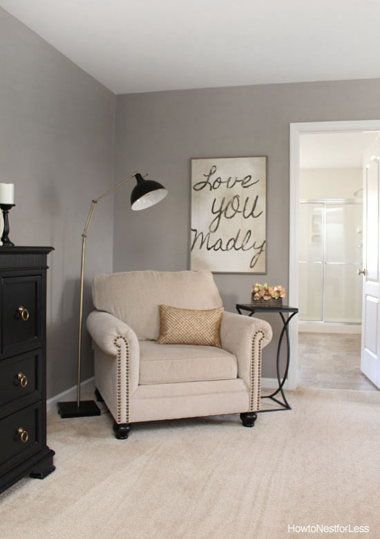 Black and gold lamp in corner above armchair.