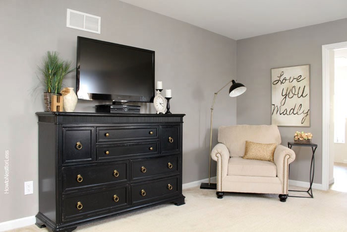 Armchair and tv on top of black dresser.