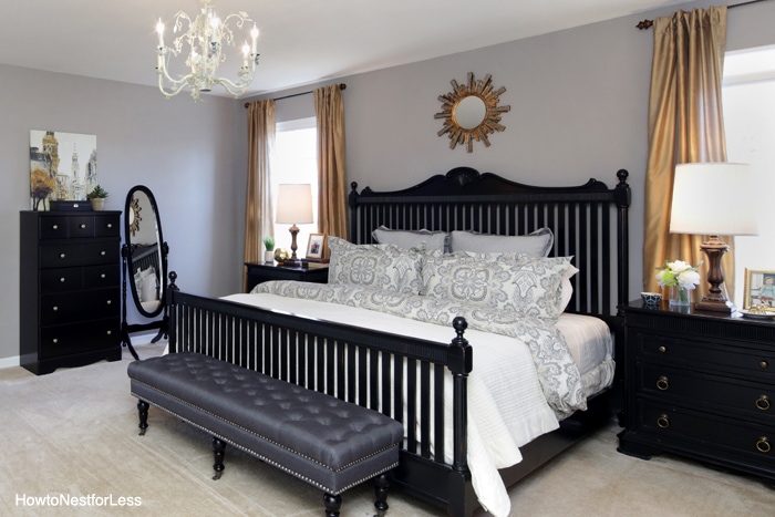 Black bed frame and gold curtains in master bedroom.