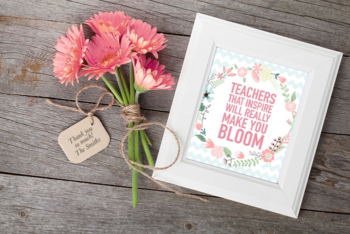 Bunch of gerbera flowers and photo frame on wooden table