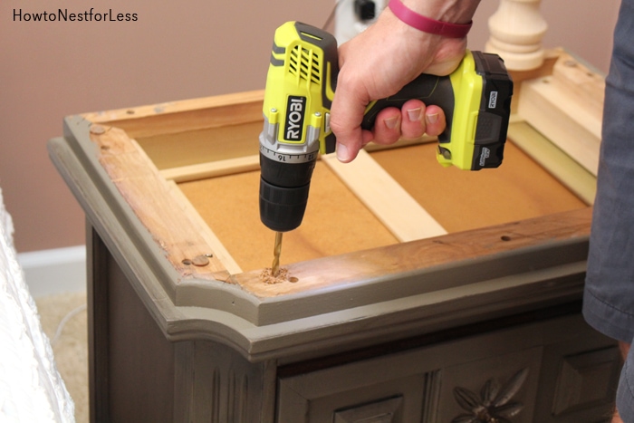 Drilling a screw hole into the night stand.