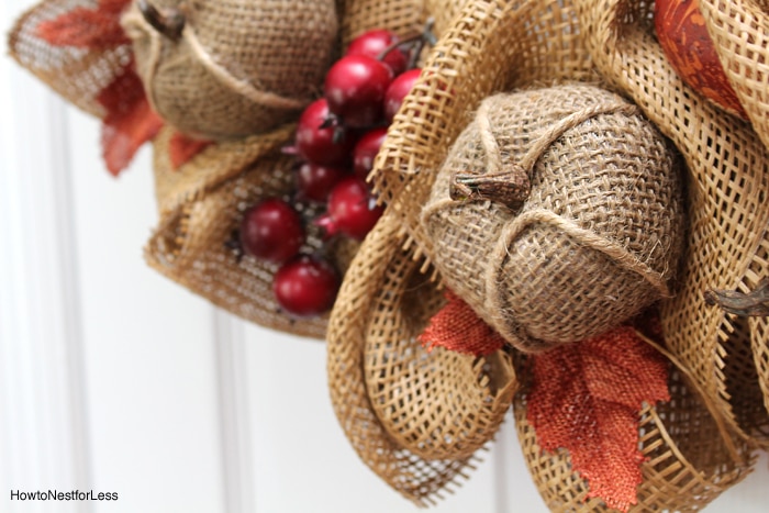 Up close picture of the wreath with red berries and mini pumpkins on the wreath.