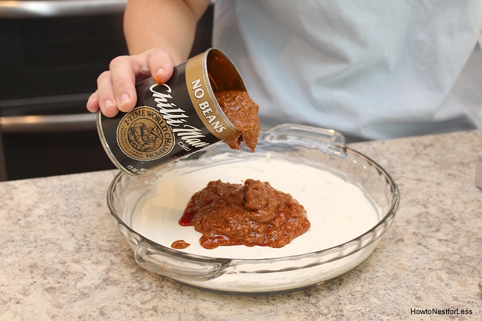 Pouring the can of chili beans over the cream cheese.