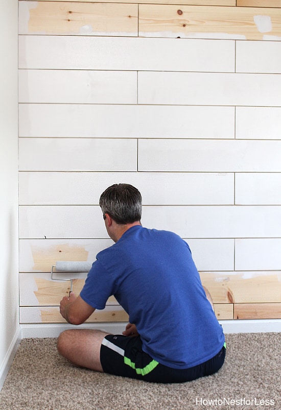 Painting the planked wall white.