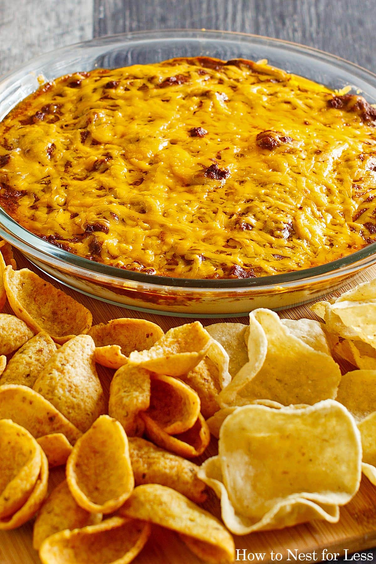 The baked chili dip on counter with chips.