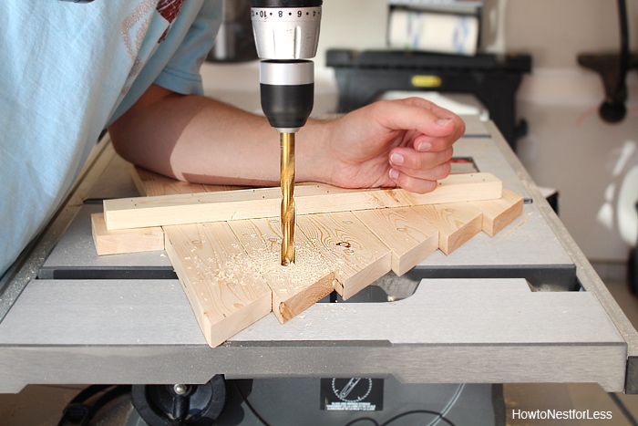 Drilling holes into the wooden tree.