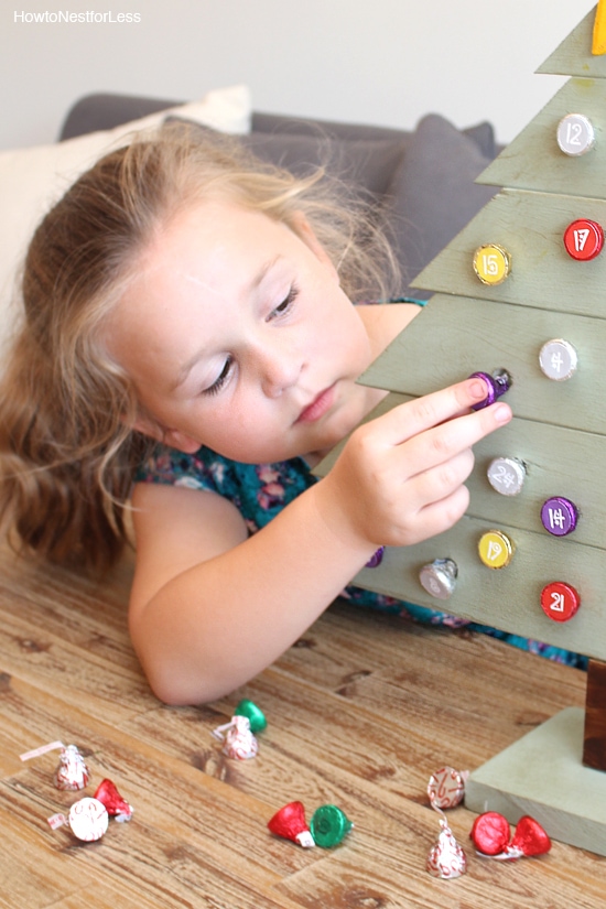 Little girl taking the candy off the tree.